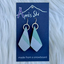 Geometric earrings made from a snowboard on a blue card with 'Après Ski' branding