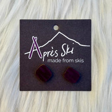 Pair of maroon earrings on a 'Après Ski' branded card against a light gray background