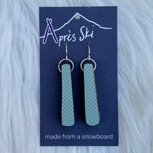 Teal earrings on a blue card with 'Après Ski' branding on a white fur background