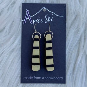 Pair of earrings on a blue card with 'Après Ski' branding against a fur background