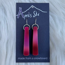 Red ombre earrings on a blue card with 'Apres Ski' branding, placed on a white fur background.